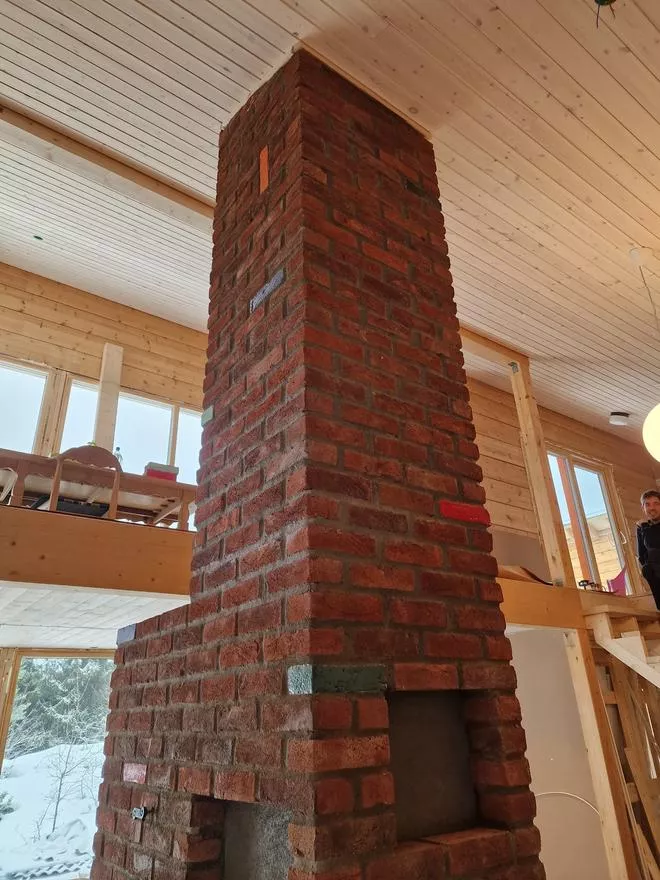 Pipe av rød murstein i rom med høyt og skrått tak. Det er godt naturlig lys.